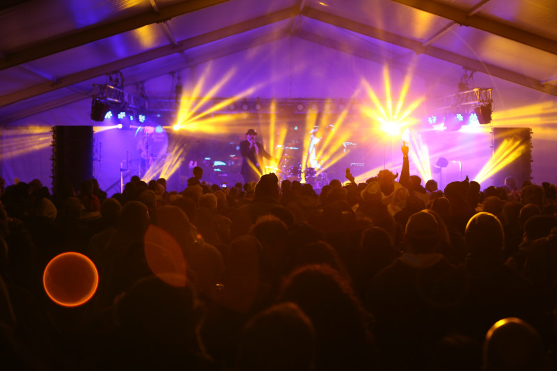 A packed crowd watching the band under stage lights at Santa Pod