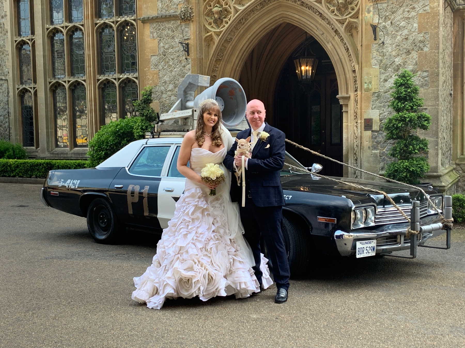 A newly married couple photographed with the Bluesmobile outside their venue