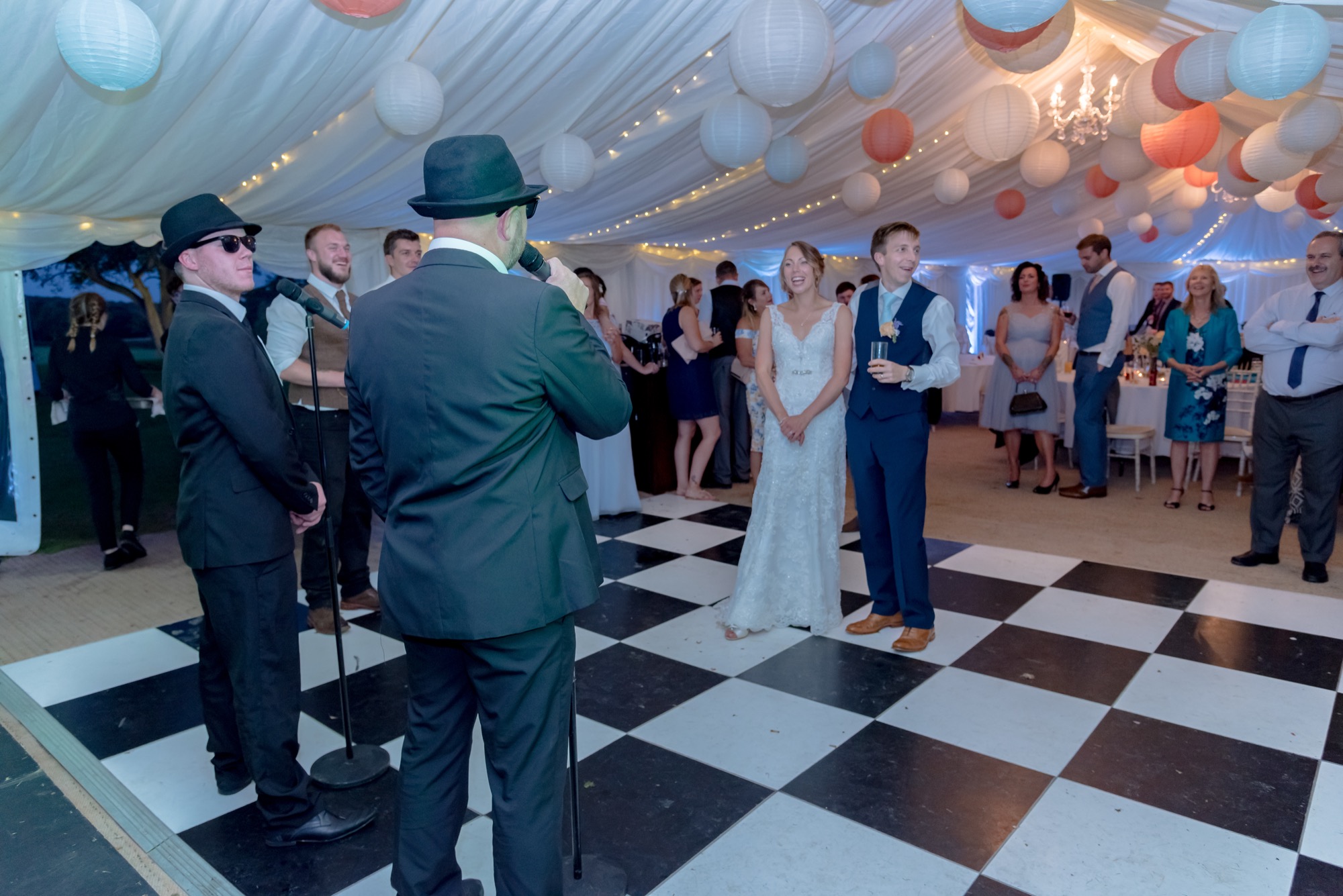 Bride and groom laughing as The All New Blues and Soul Revue perform at their wedding