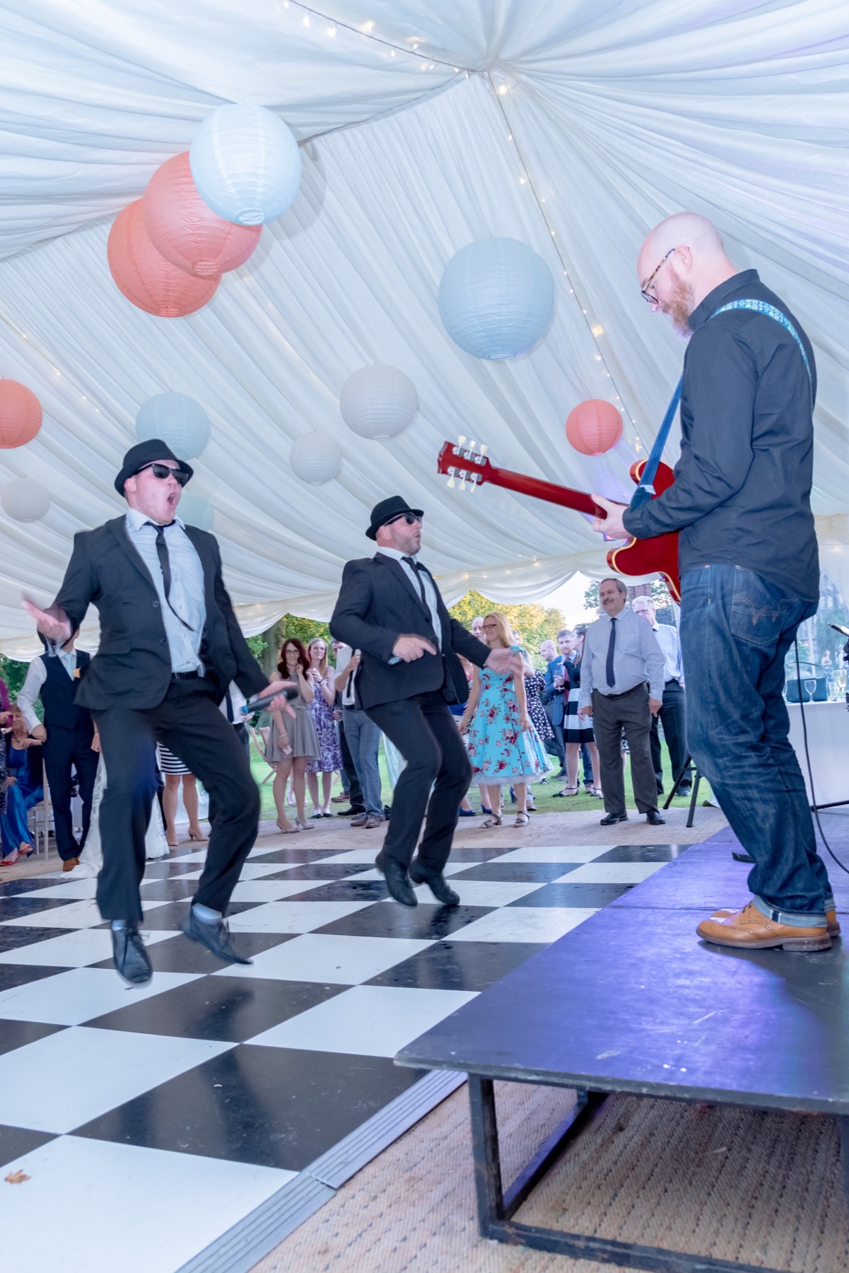 Jake and Elwood dancing with the guitarist during a marquee wedding